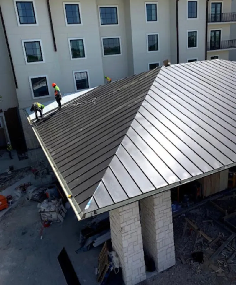 Crew installing standing seam metal roof panels on a commercial project in Grass Valley